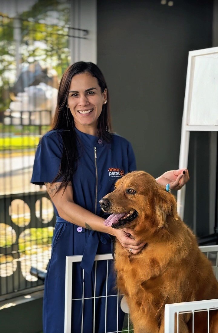 Médica veterinária da Amor e Patas ao lado de um golden retriever, dentro da clínica